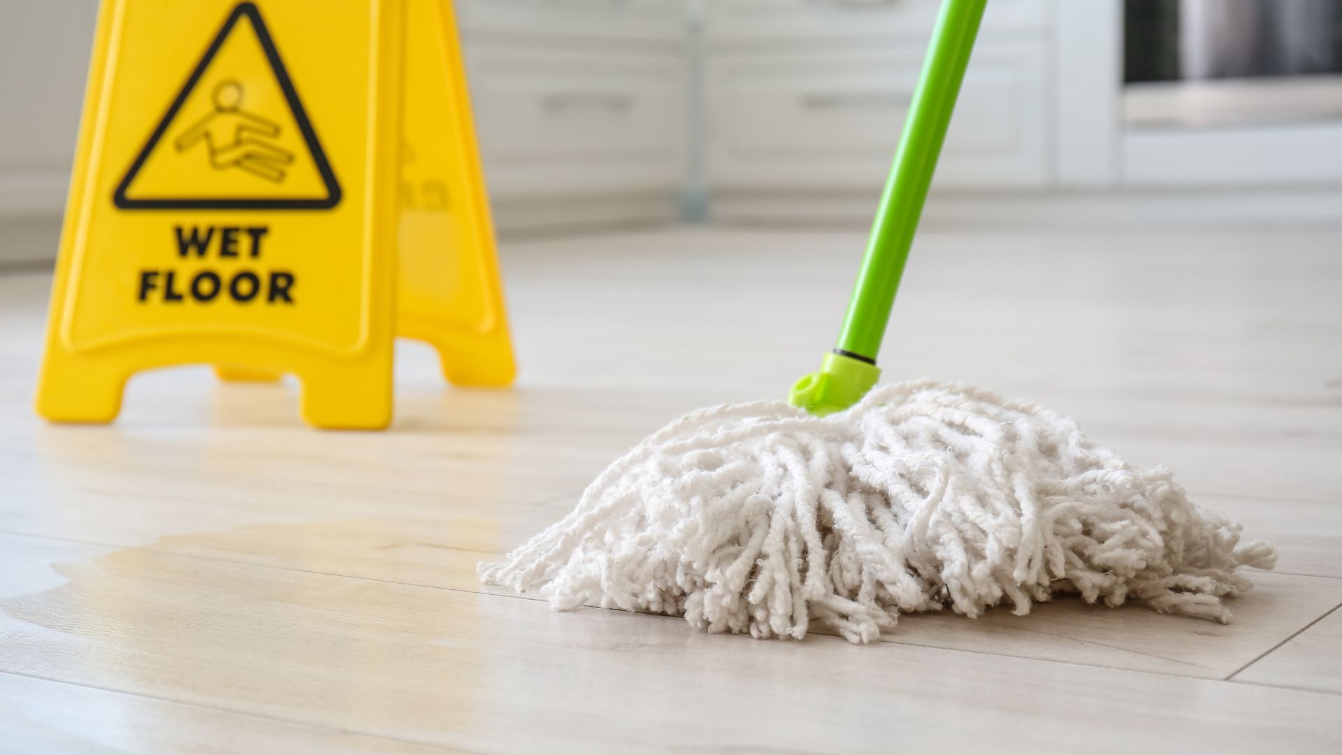 Mop and a wet floor sign