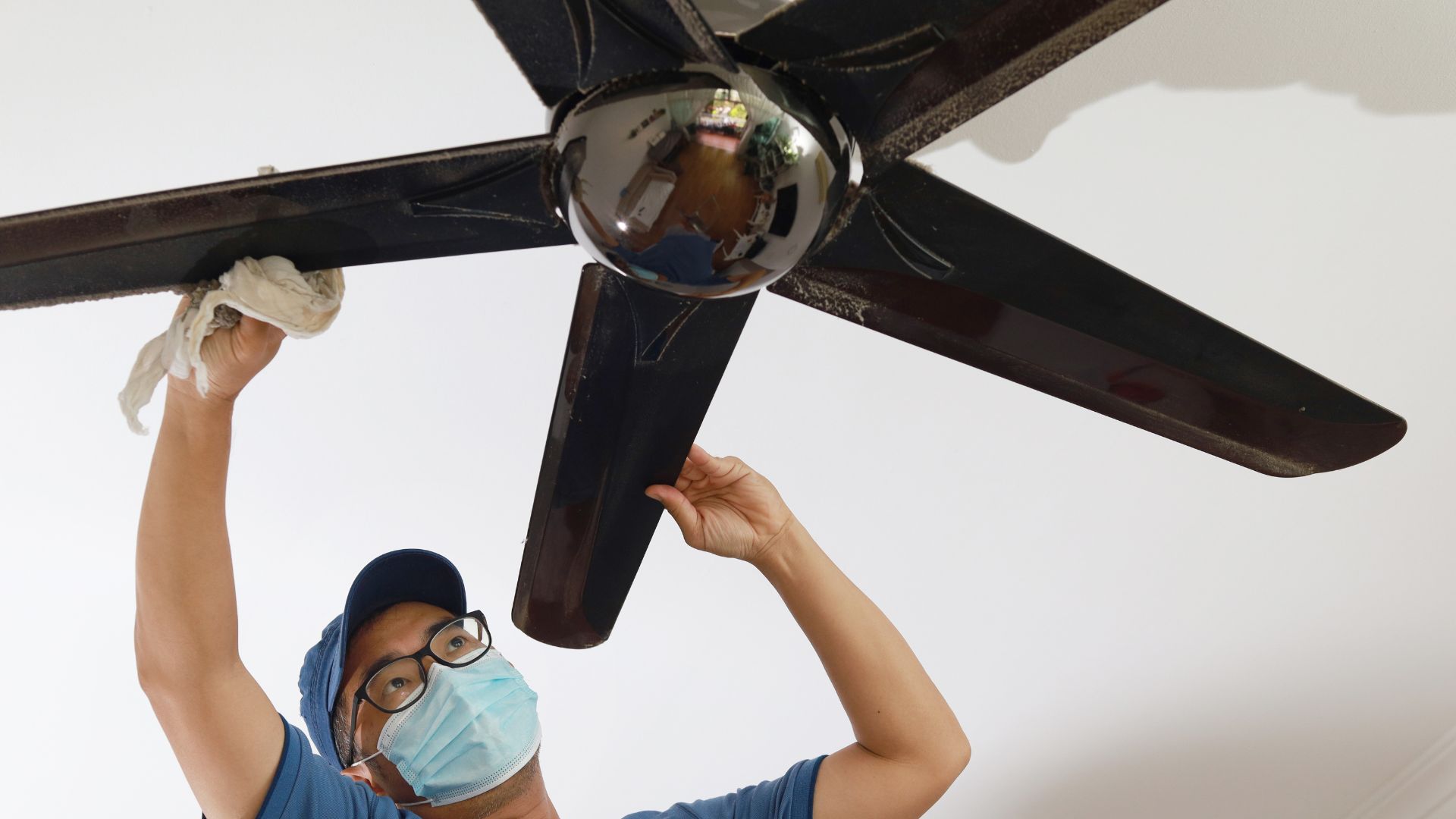 Men cleaning ceiling fan