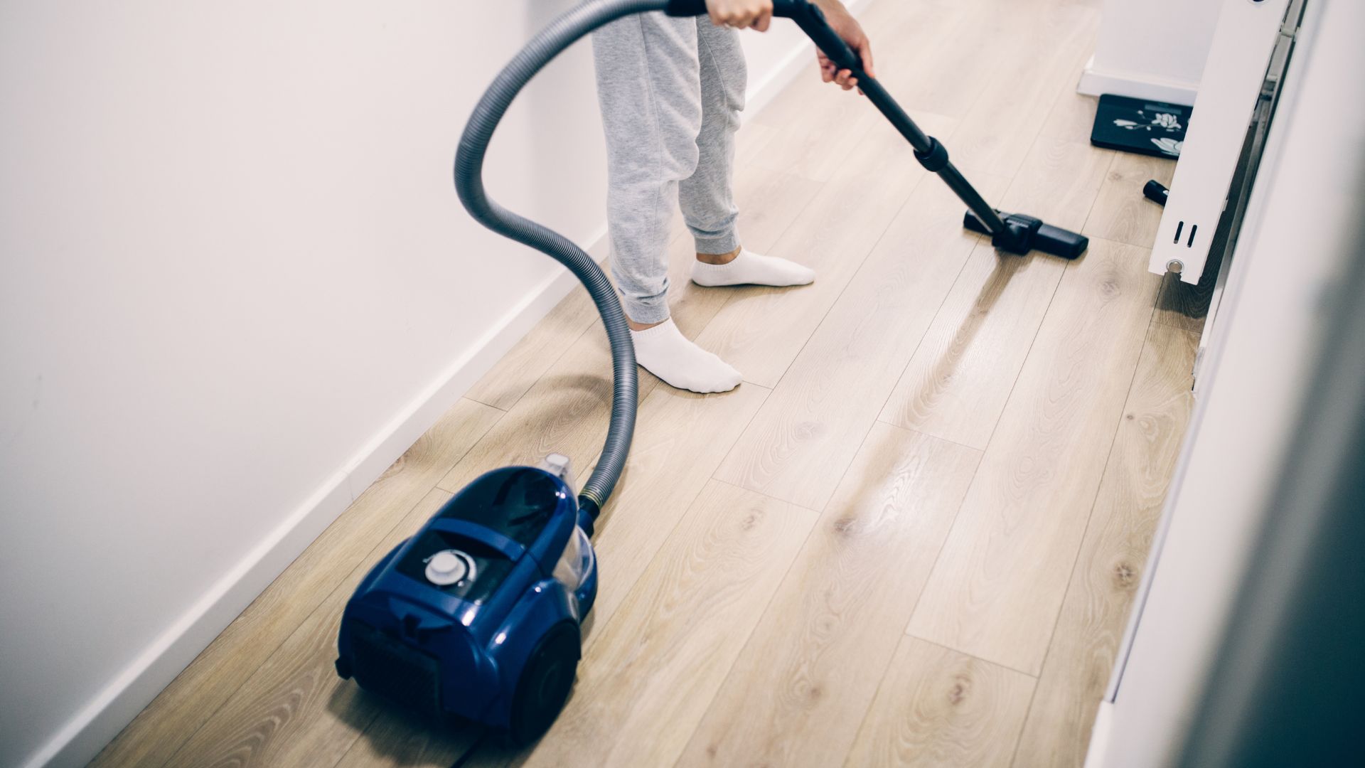 Cleaner using vacuum on wood flooring