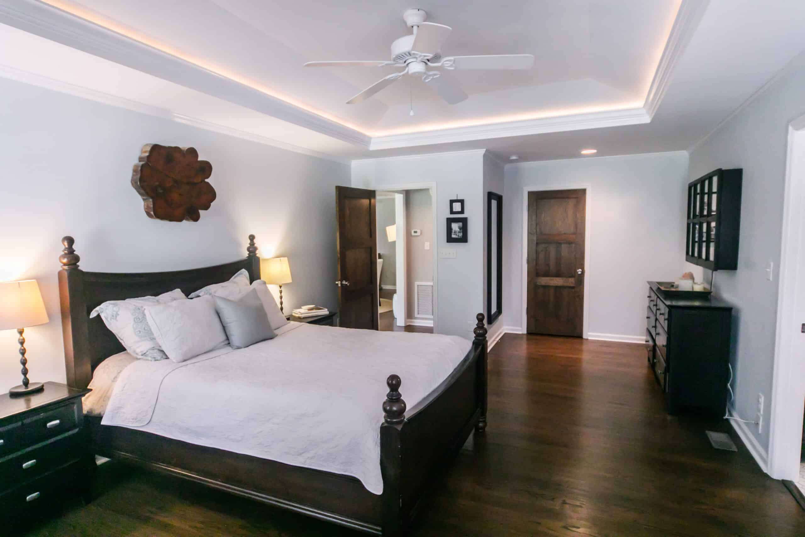 A cleaned master bedroom with king size bed and tray ceilings with uplight